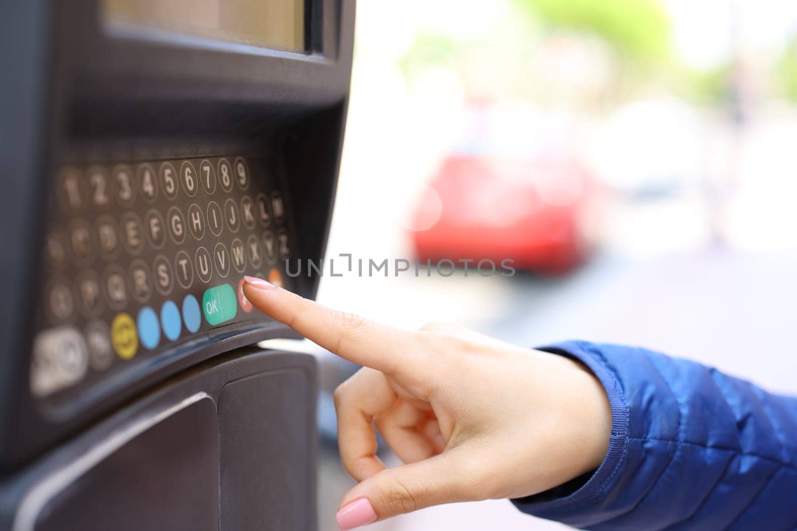 Close up portrait of a woman hand using parking meter in the street