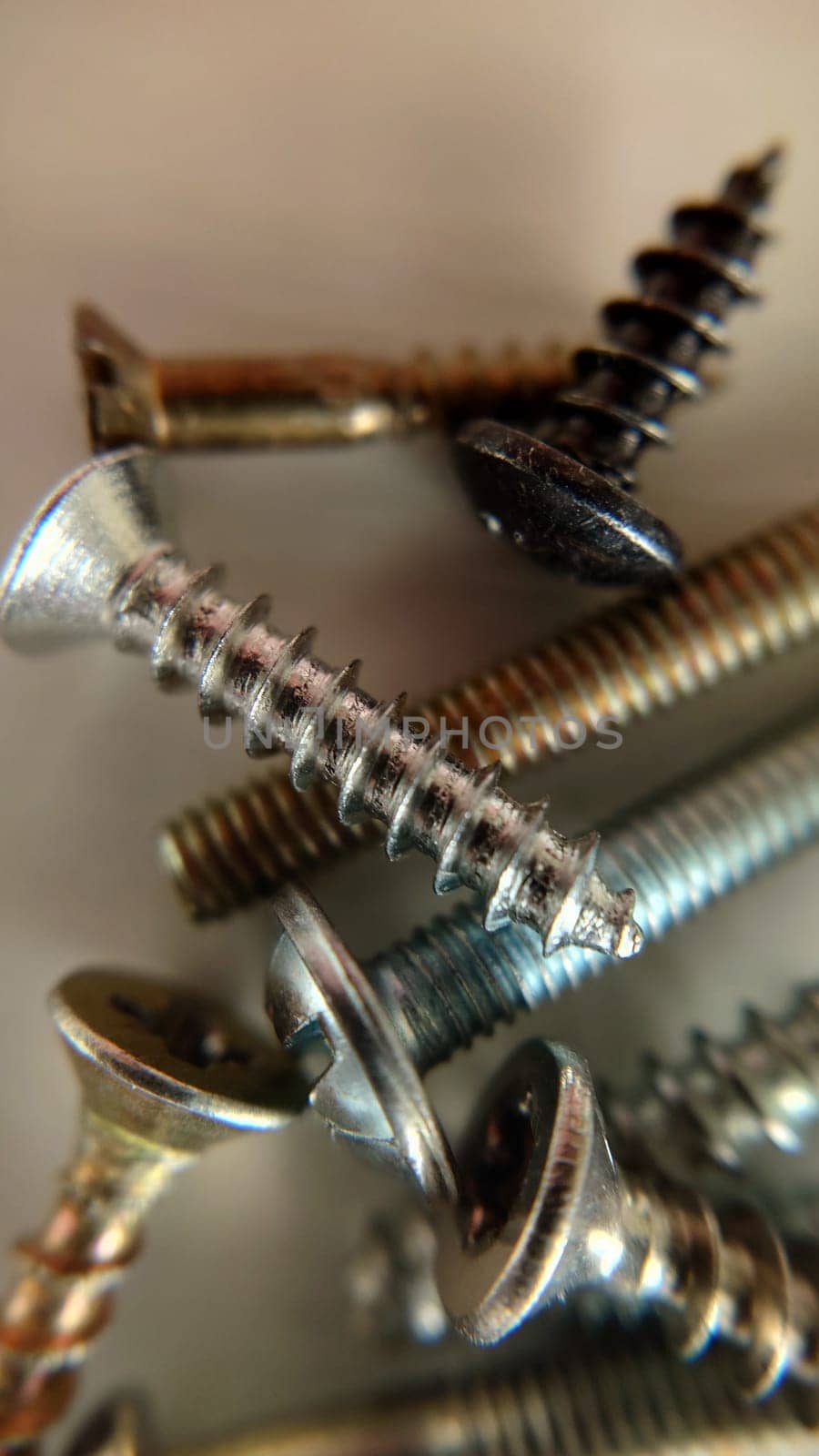 Background image of the screws of the bolts lying on the table. Macrophotography.Texture or background.Selective focus.