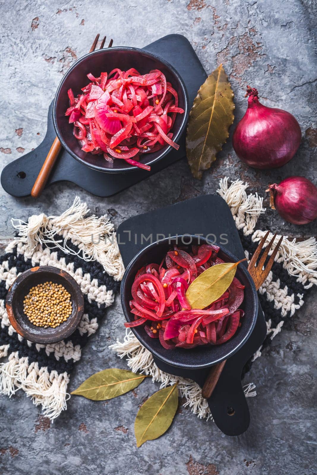 Pickled red onions in bowl on a gray background. Appetizer, condiment or topping, healthy fermented food.