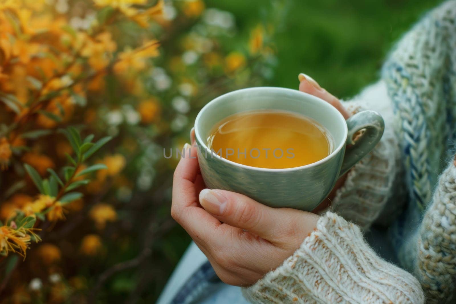 Hands holding a cup of herbal tea, sipping slowly to unwind and de-stress