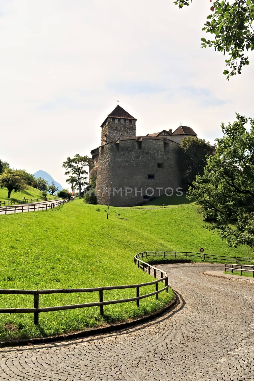 A cobble stone road, street is winding its way up to the Vaduz Castle, Schloss Vaduz, the palace and official residence of the Prince of Liechtenstein in Vadzu, Liechtenstein 2022