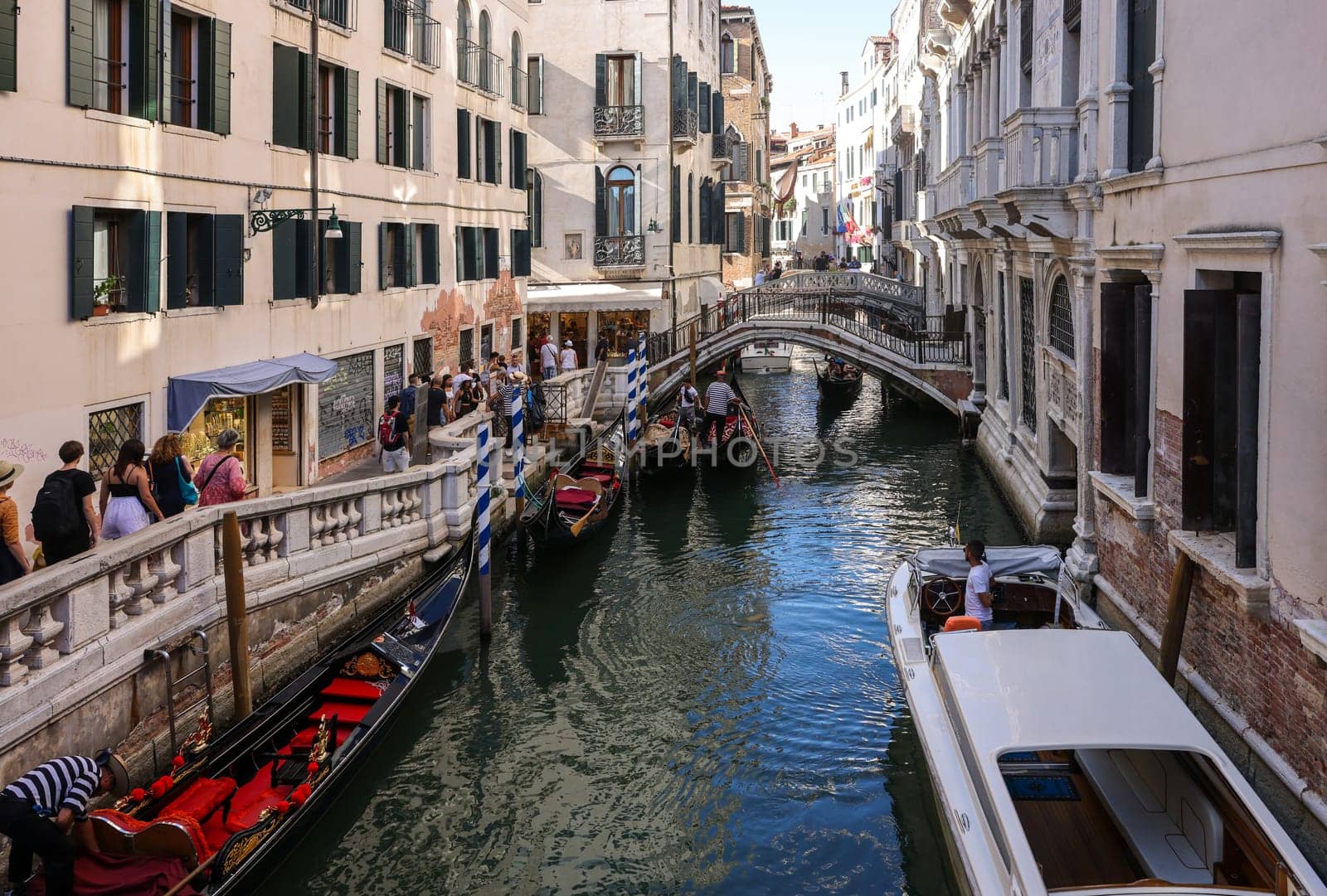 Venice, Italy - September 5, 2022: One of the most recognizable tourist attractions in the world - a gondola cruise through the narrow canals in Venice