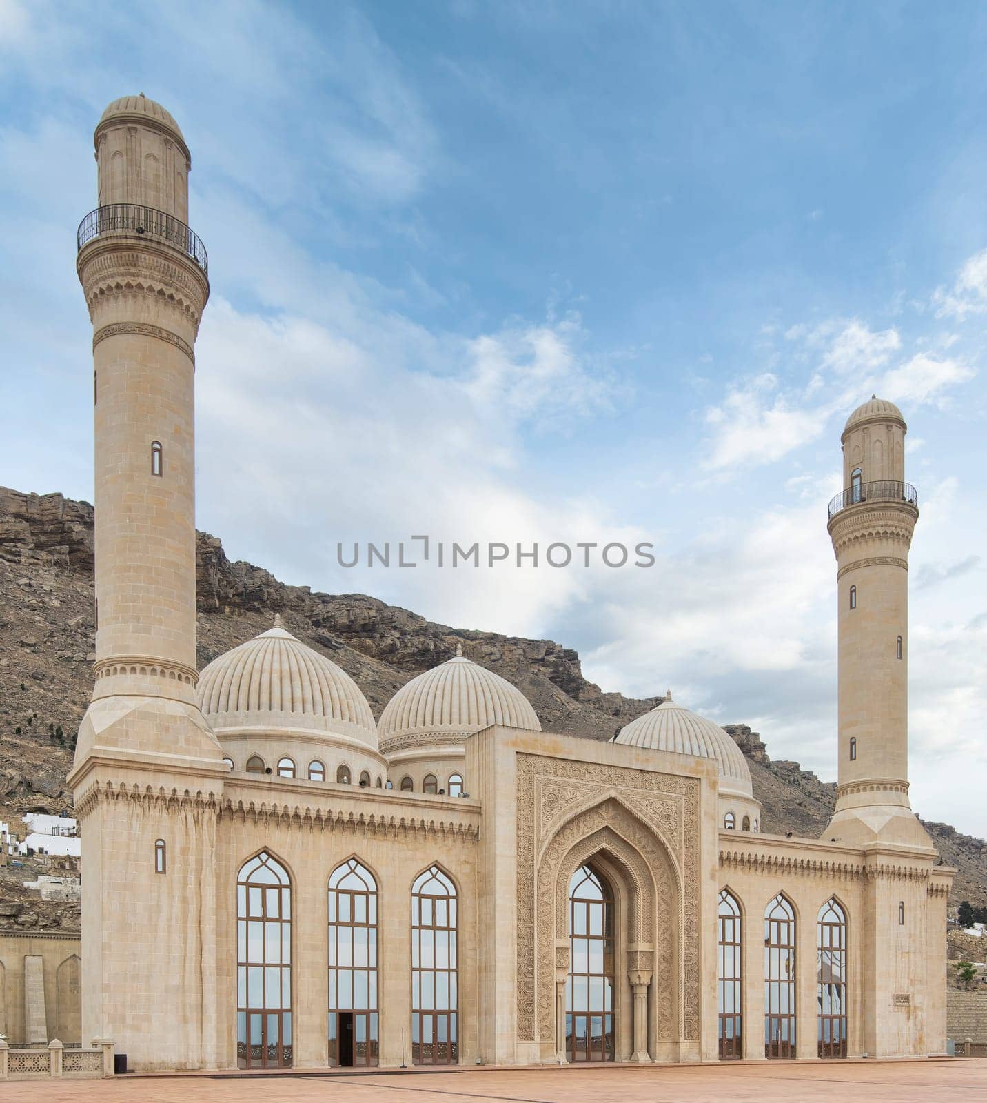 The Bibi-Heybat Mosque in Baku, Azerbaijan showcases stunning Islamic architecture with minarets, domes, and intricate details. Set against hills, it stands out against the clear blue sky