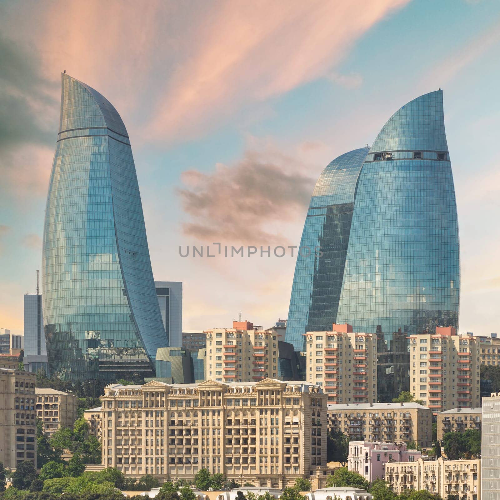 The iconic Flame Towers of Baku, Azerbaijan, stand tall against a vibrant sunset sky. These modern skyscrapers are a symbol of the citys dynamic growth and futuristic vision