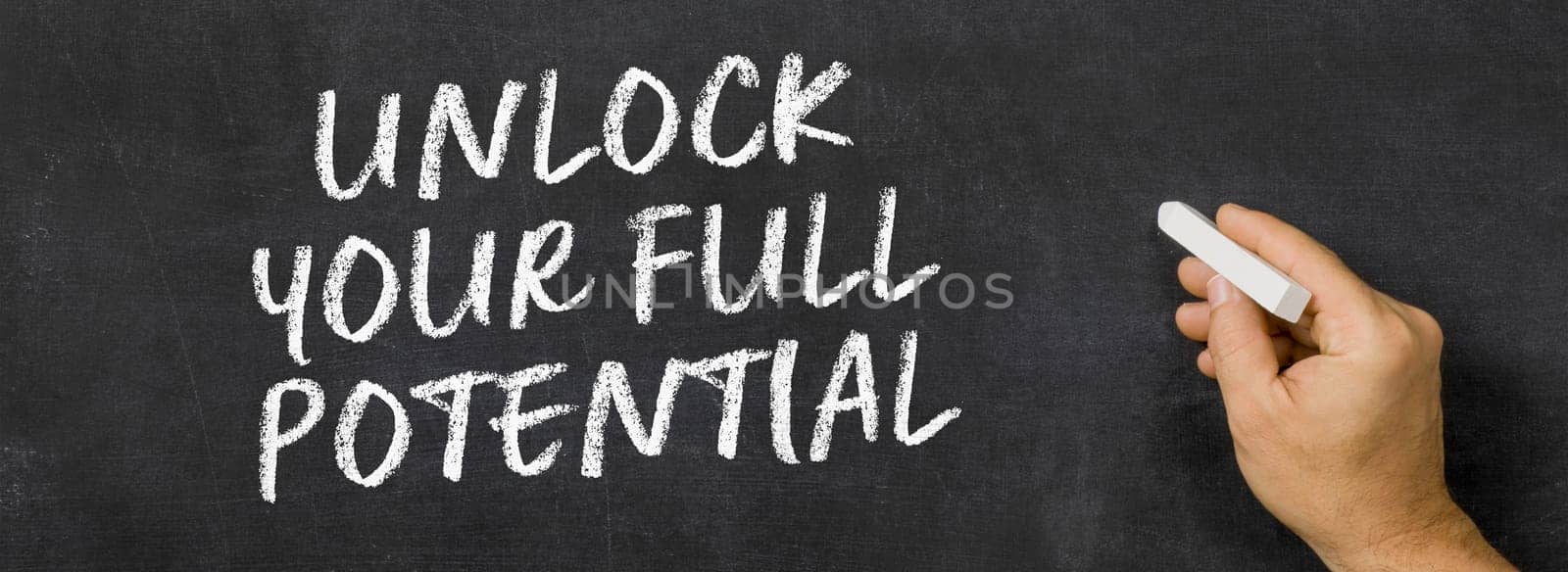 Text written on a blackboard - Unlock your full potential