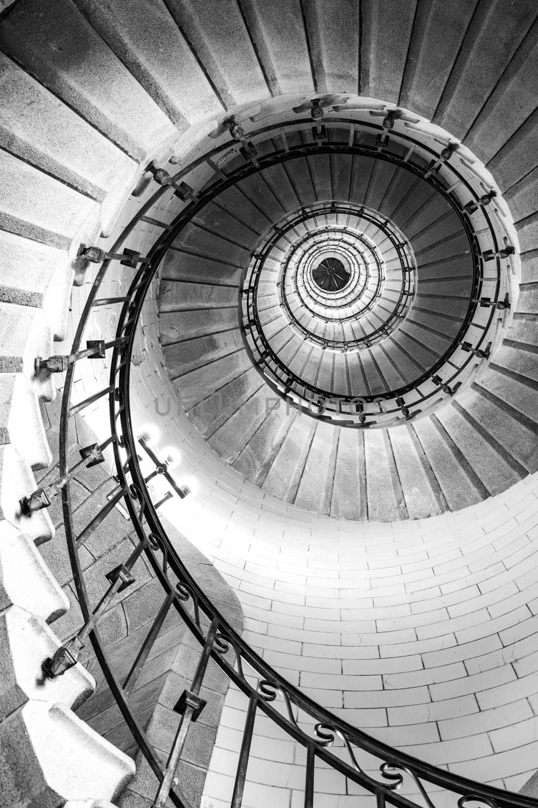 Plouguerneau, France - August, 08 2017 : Black and white vertical real photography of Spiral stairs inside the lighthouse, brittany,france