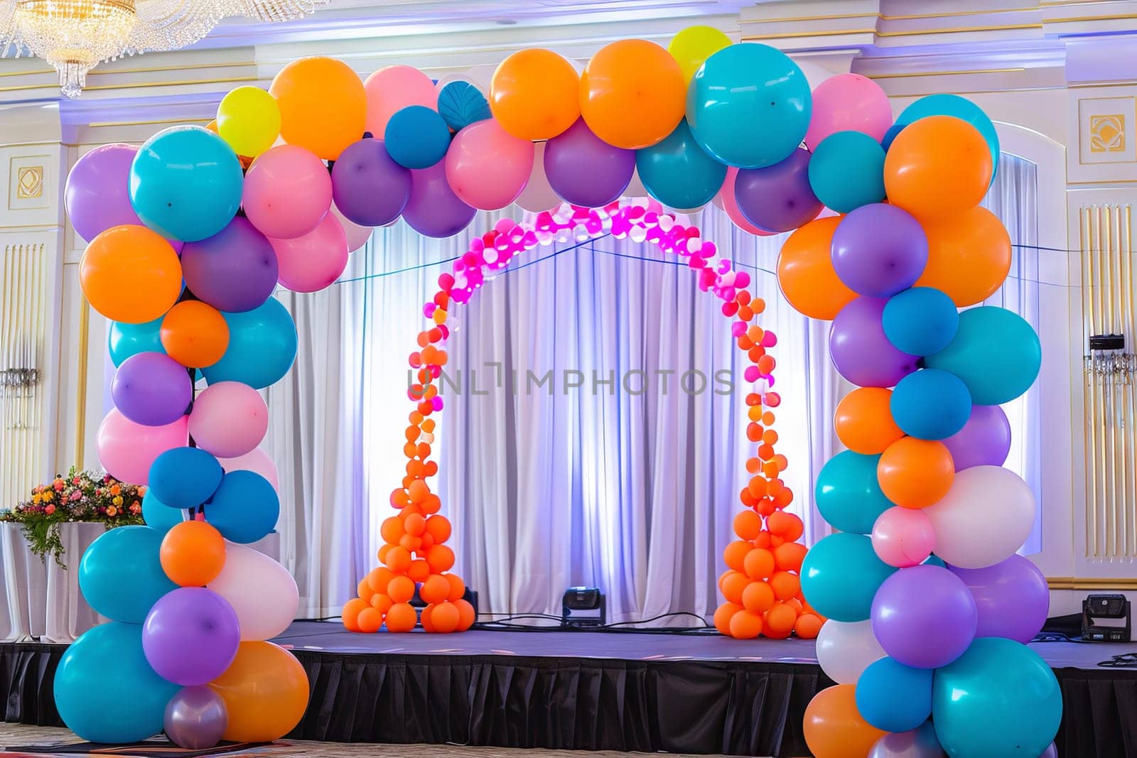 Colorful balloon arch framing a stage at a charity event, creating a festive backdrop