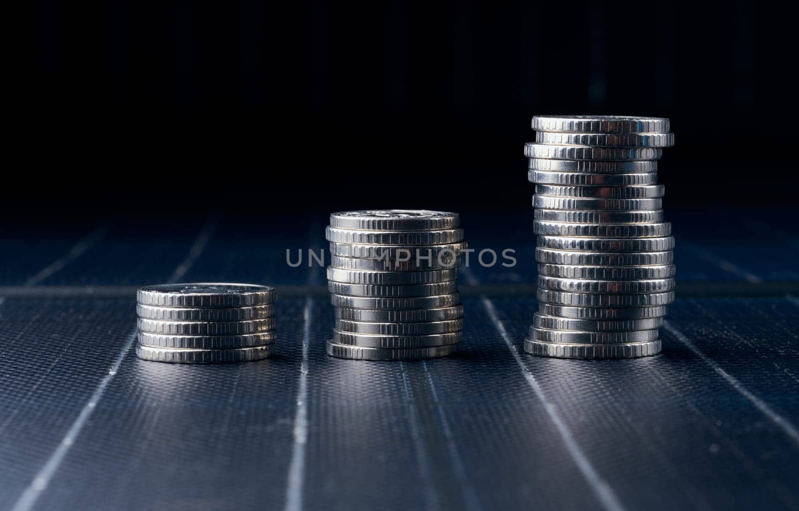 Stacks of metal coins on a black background, financial growth, price increases