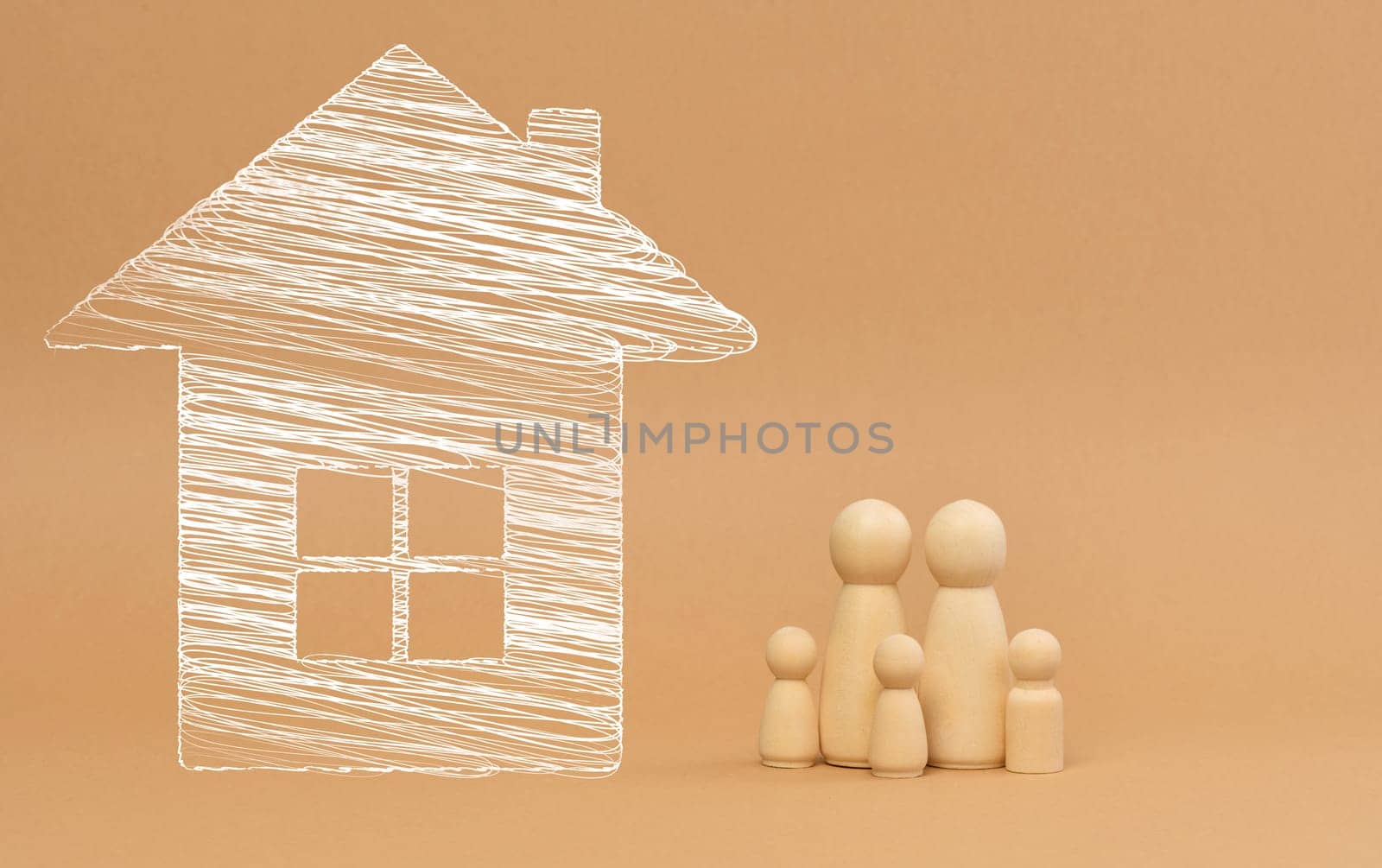 House and wooden miniature figurines of a family on a brown background. The concept of selling and buying real estate, investment