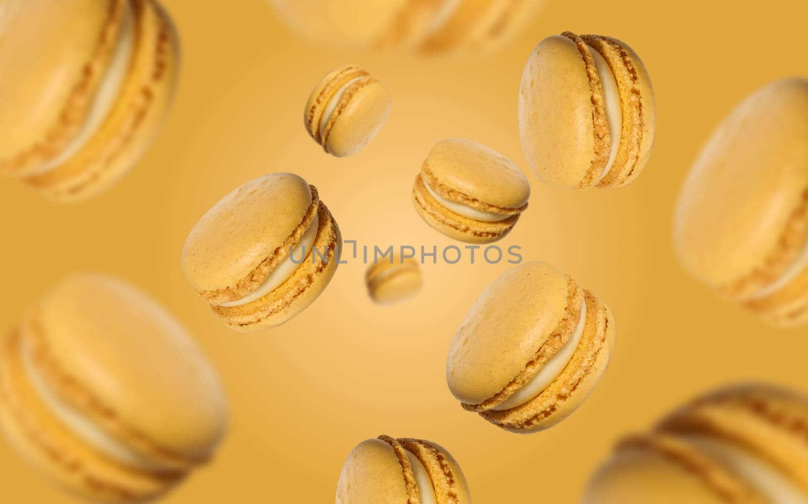 Yellow macarons with white cream levitate on a yellow background, delicious dessert