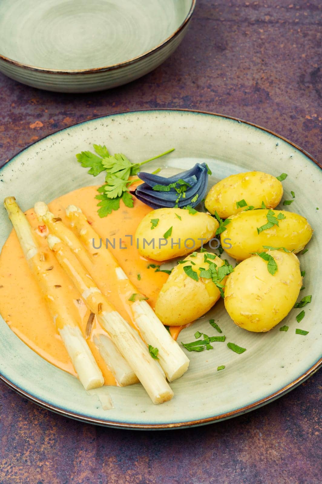 Vegan food, new boiled potatoes and white asparagus.