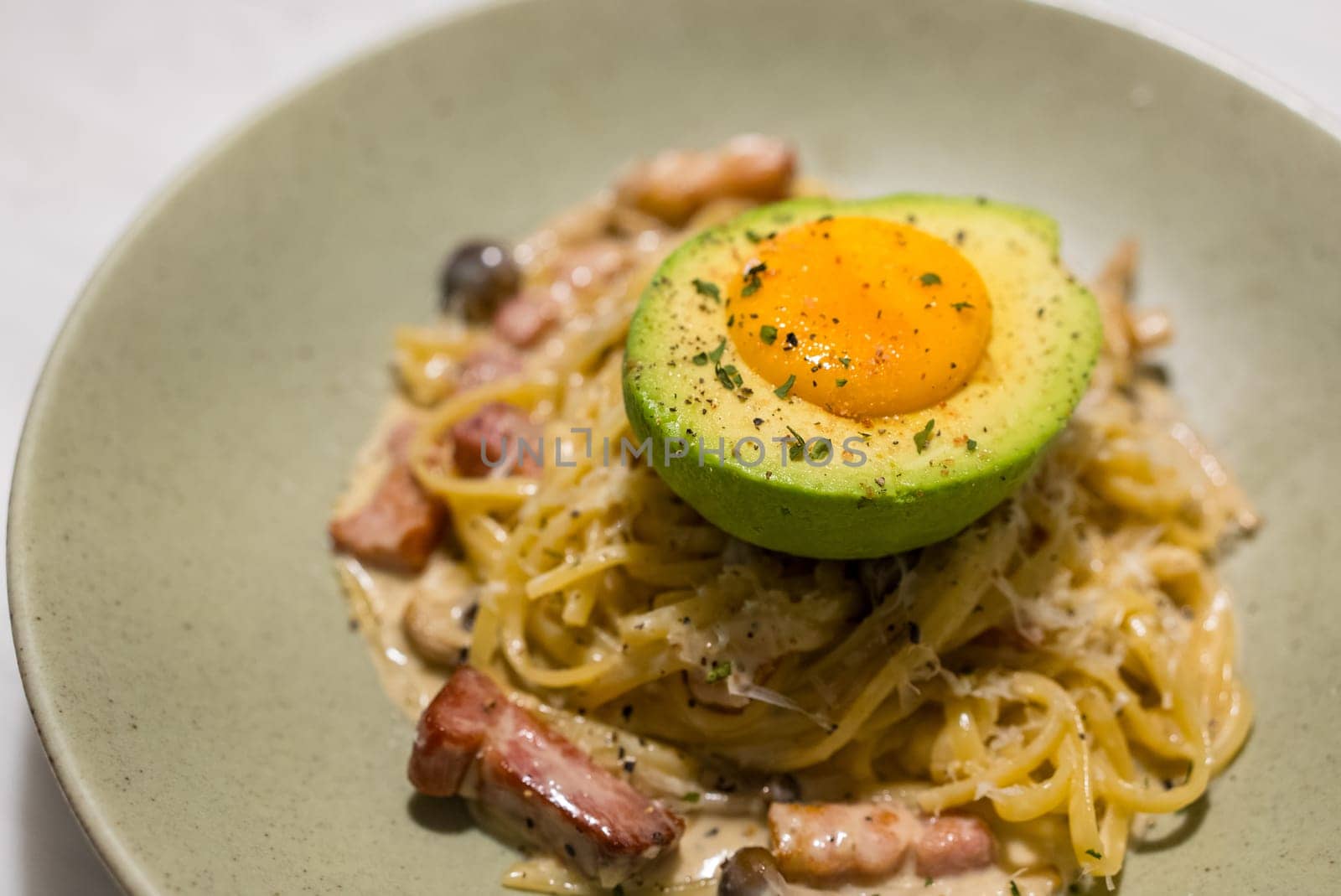 Spaghetti Carbonara with avocado on the dish