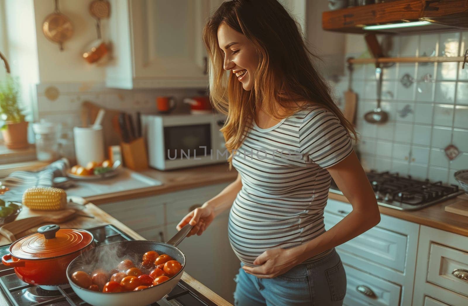 A pregnant woman in a striped shirt is sautéing tomatoes in a skillet on a stove in a home kitchen setting