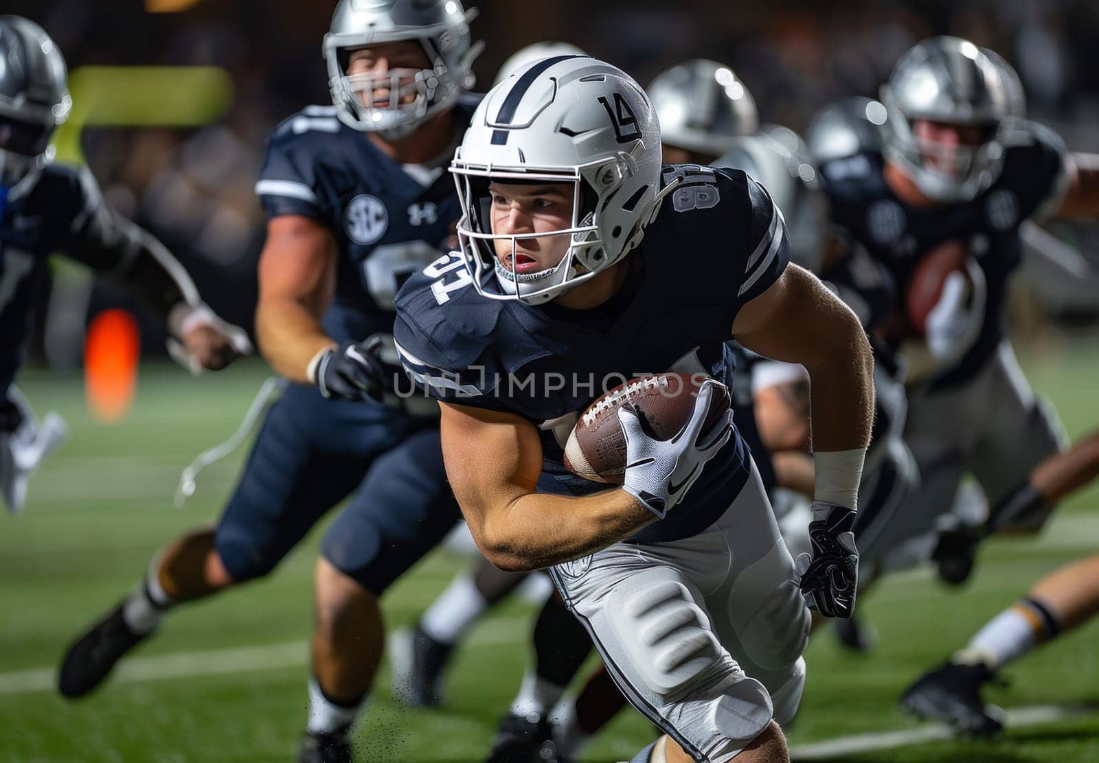 A football player, wearing a blue and white uniform, runs with the ball during a game, showcasing his determination and skill under the bright lights of a Friday night game. The players focus is evident as he tightly grips the ball, his eyes fixed on the field ahead. The background is blurred, creating a sense of motion and highlighting the players dynamic movement.