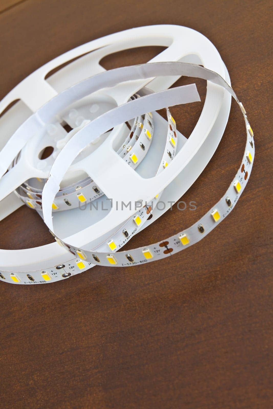 LED strip wound on a roll of brown wooden board