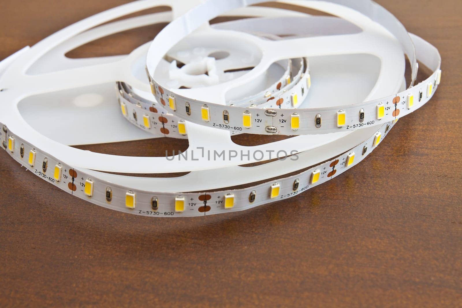 LED strip wound on a roll of brown wooden board