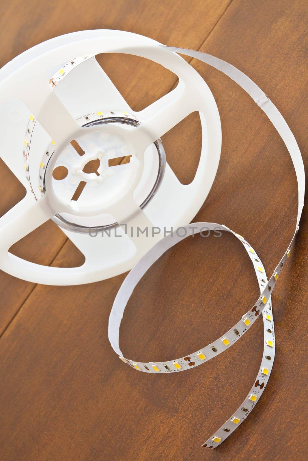 LED strip wound on a roll of brown wooden board