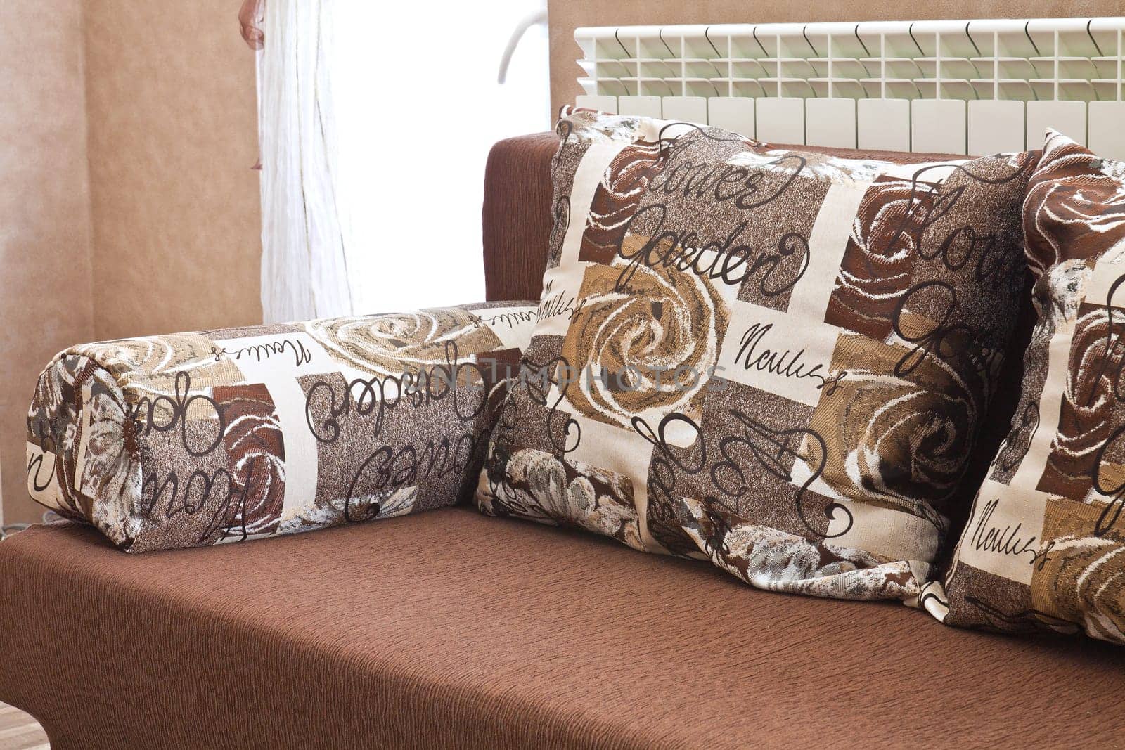 Detail from home sofa with pillows in beige brown tones