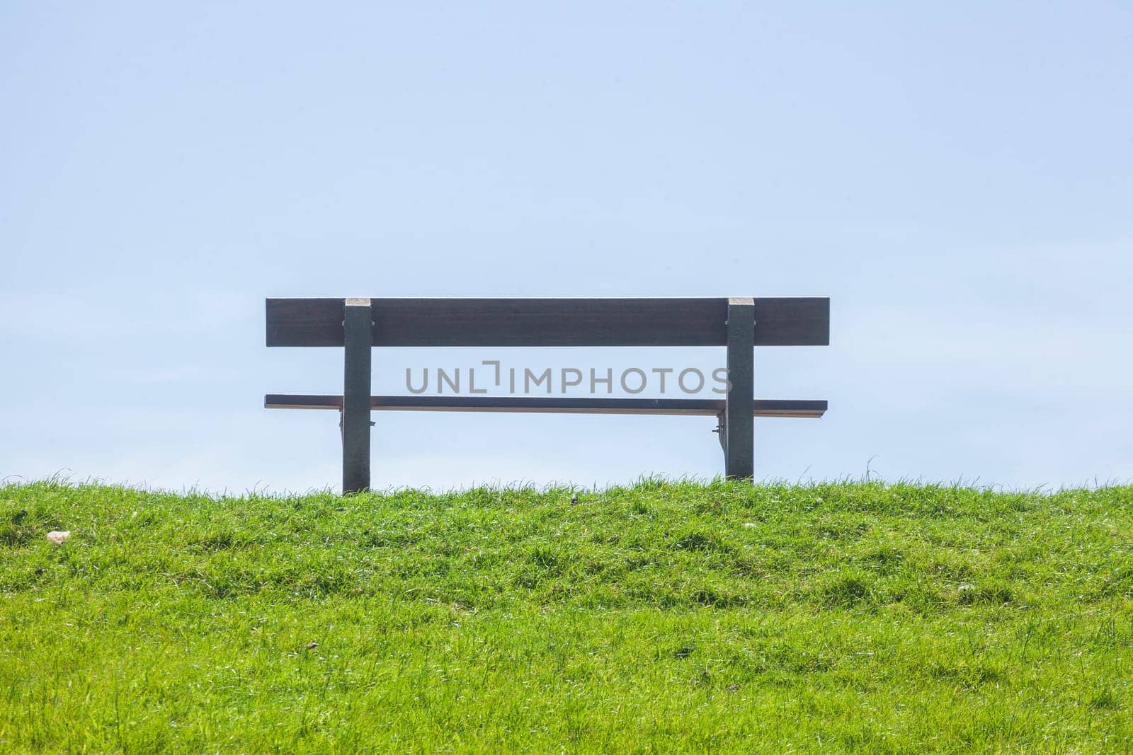 Wooden bench on a dyke, blue sky, Germany