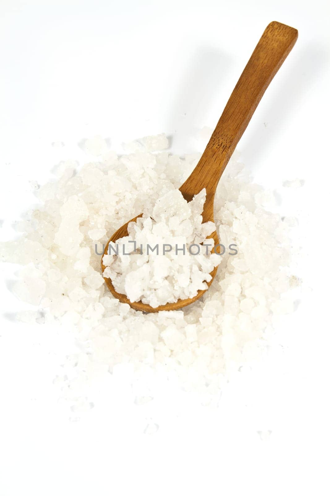 Sea salt crystals in clay pot with a wooden spoon
