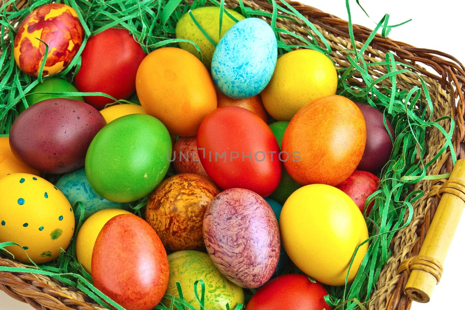 Colorful dyed Easter eggs placed in a wooden basket