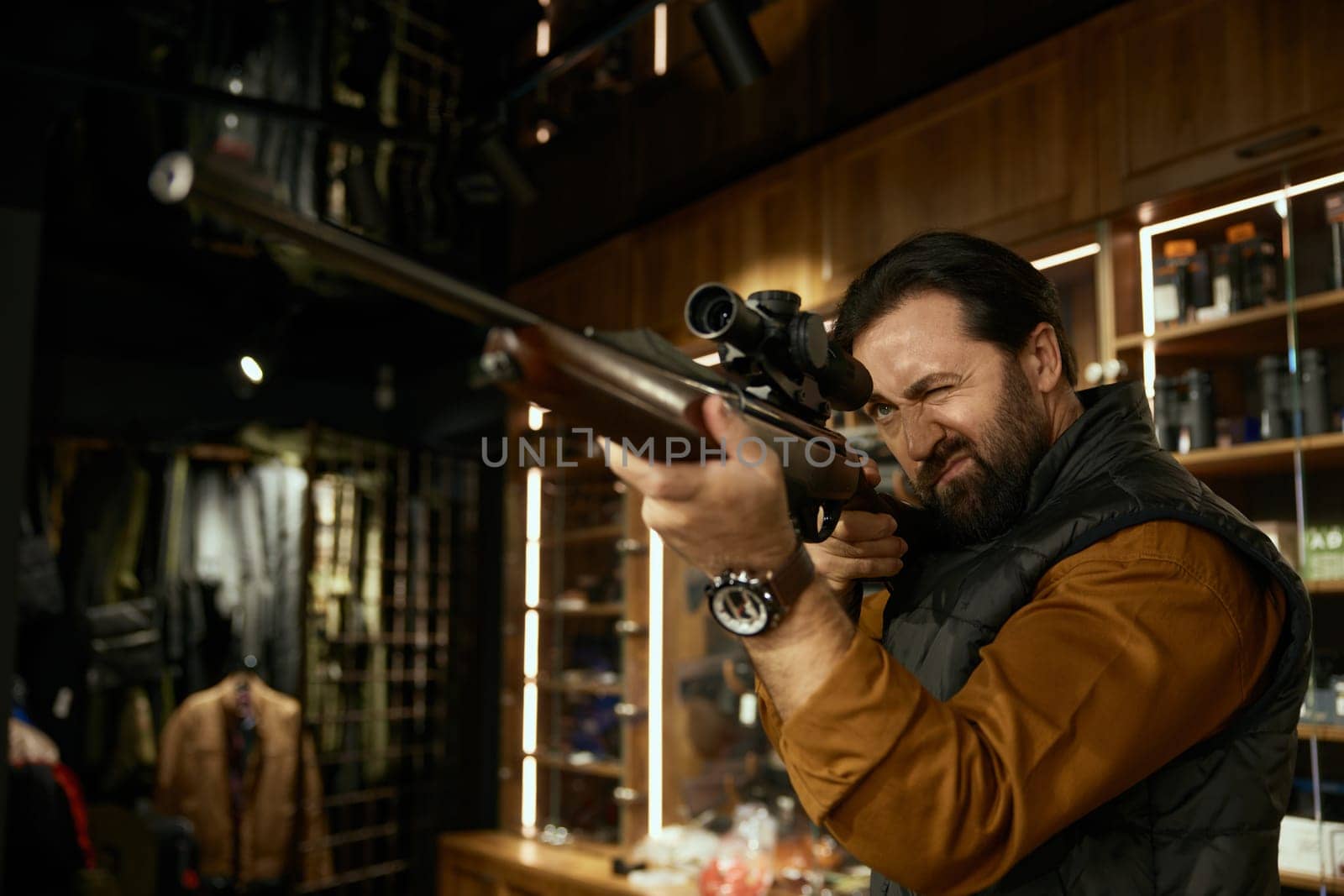 Man hunter customer aiming gun with telescopic sight while choosing ammunition in weapon store. Armament assortment for hunt hobby