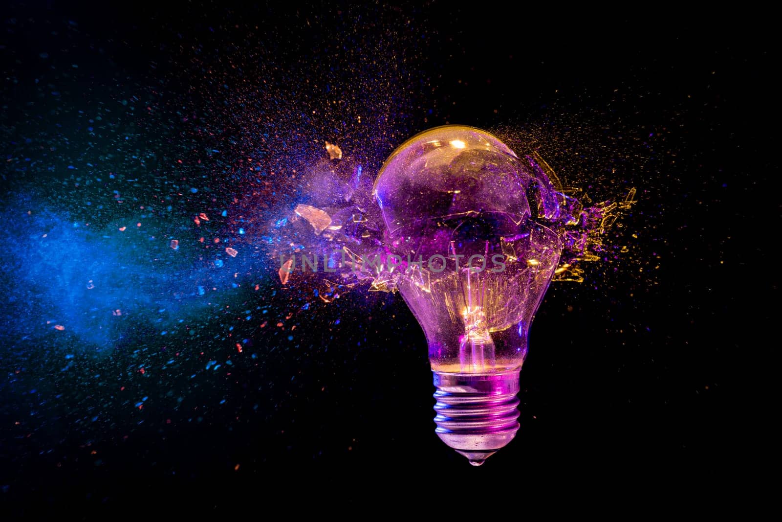 Colorful light bulb exploding  glass  flying everywhere  black background