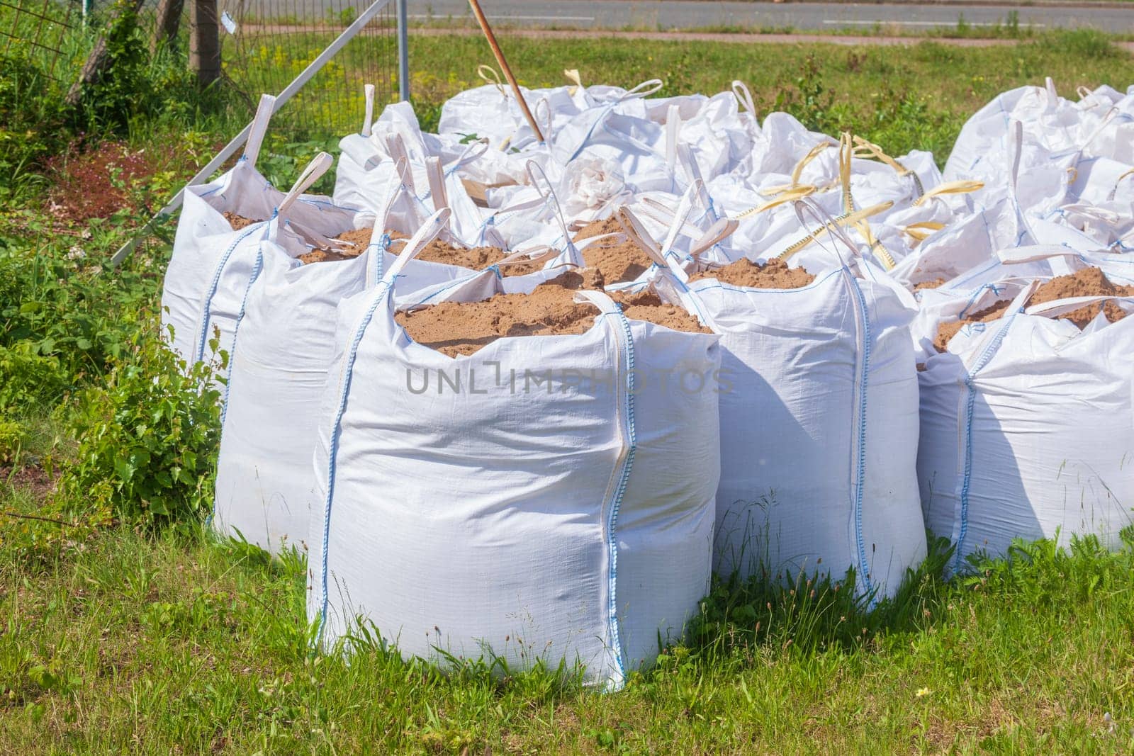 White garbage bags with construction waste standing on a meadow, Germany