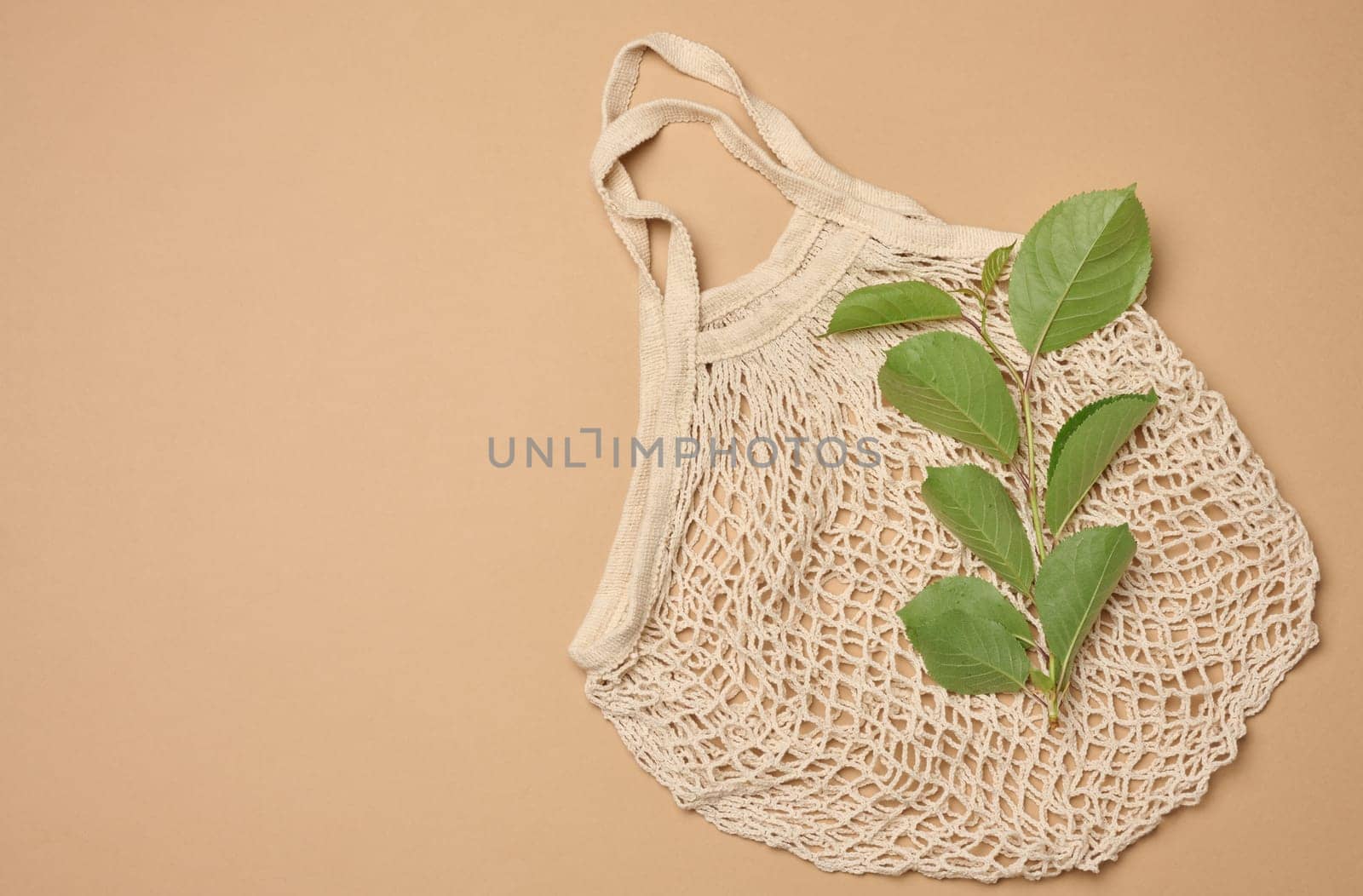 Textile grocery bag on brown background, top view. Copy space