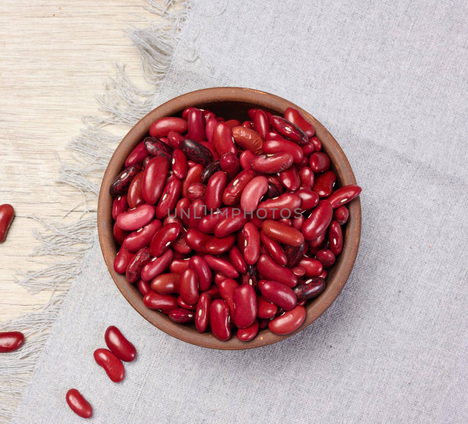 Raw red beans in a plate on the table, top view