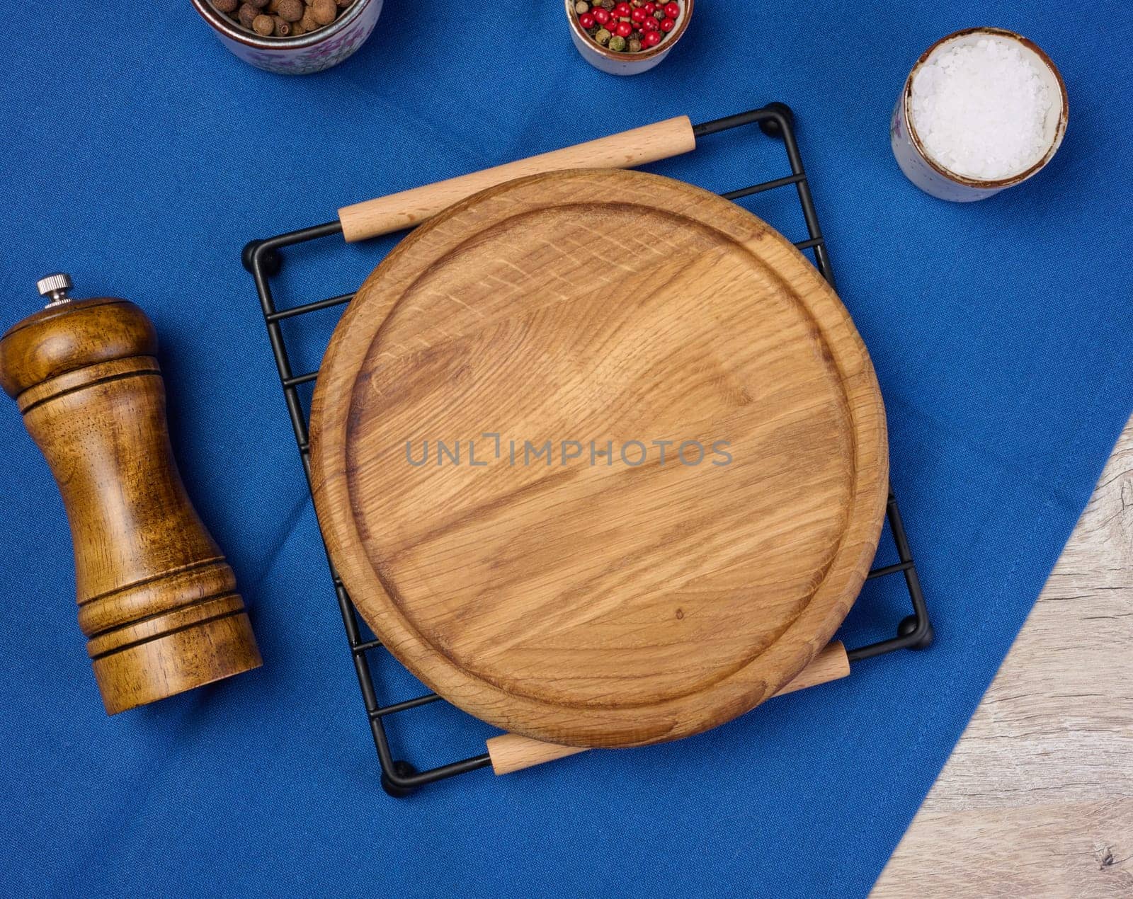 Round empty wooden plate on the table, top view