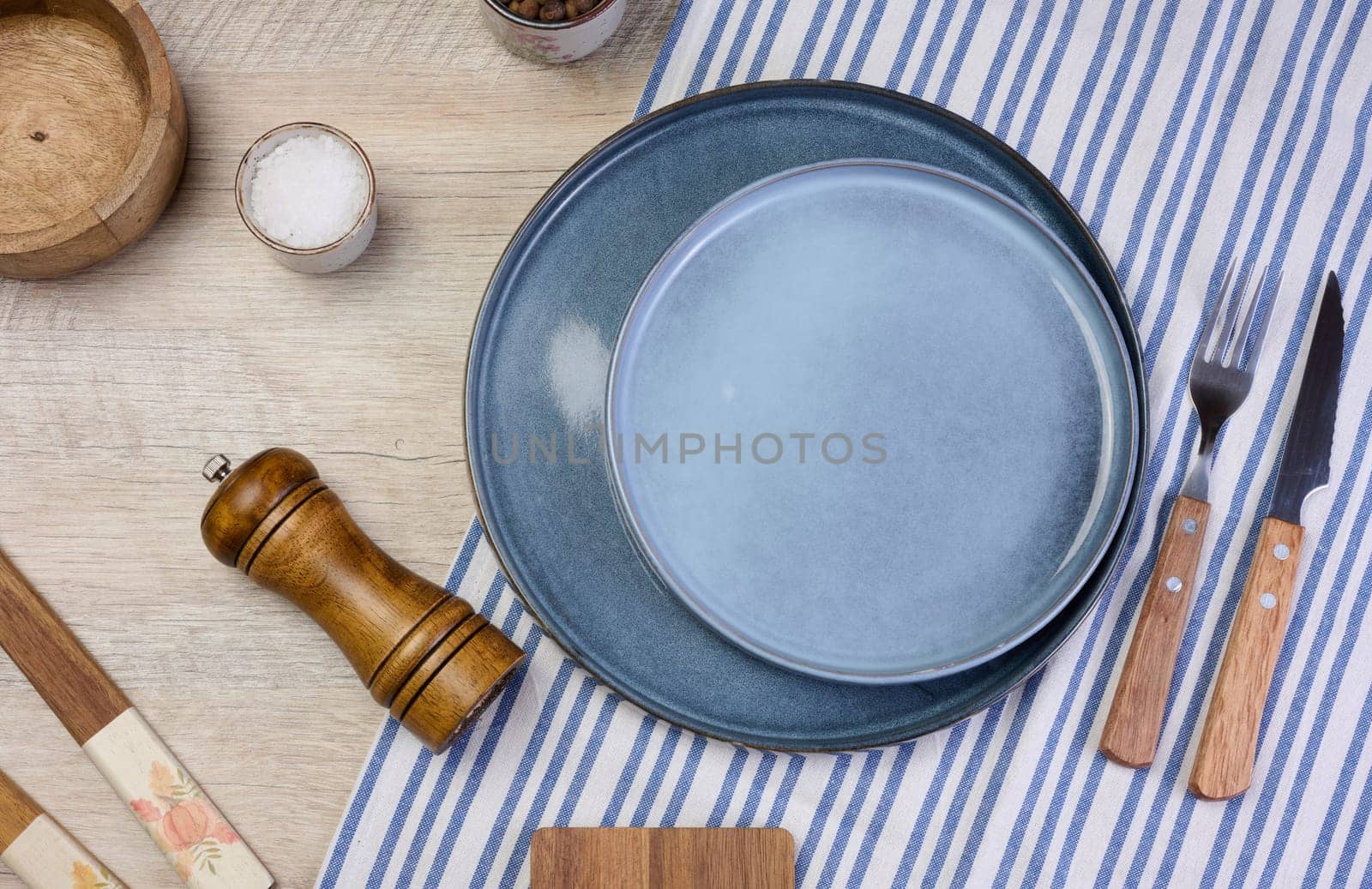 Empty round ceramic plate on the table with spices, top view