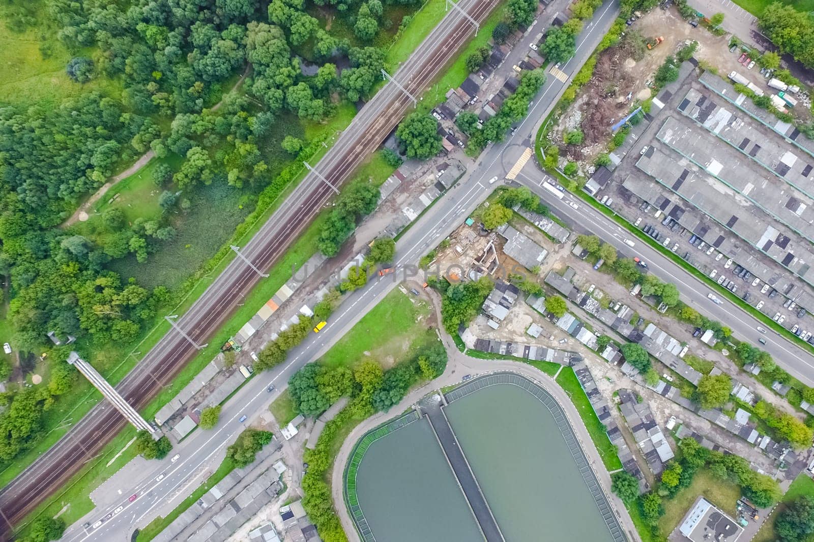 Top view of the urban lake. Lake, road in the city and parking
