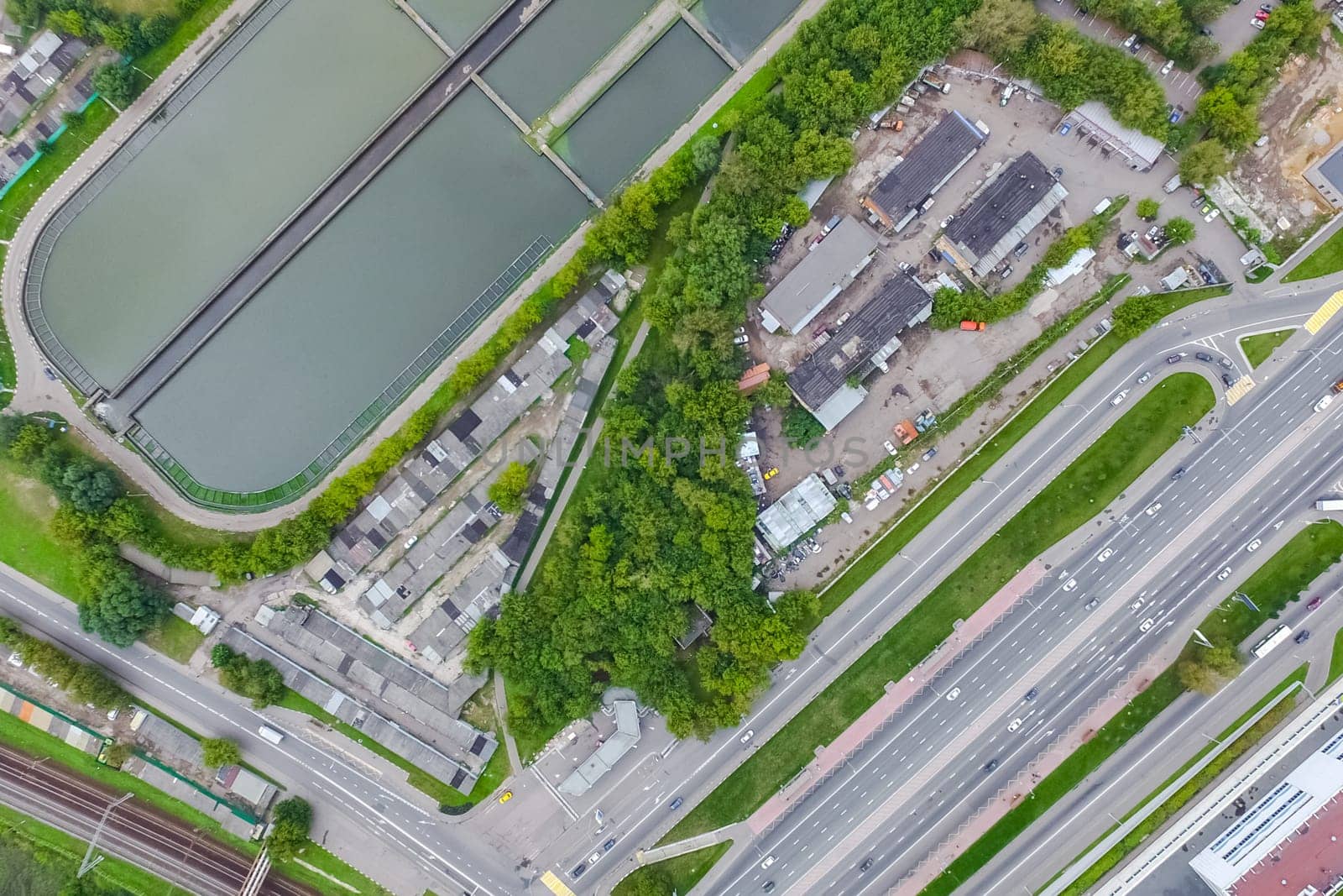 Top view of the urban lake. Lake, road in the city and parking