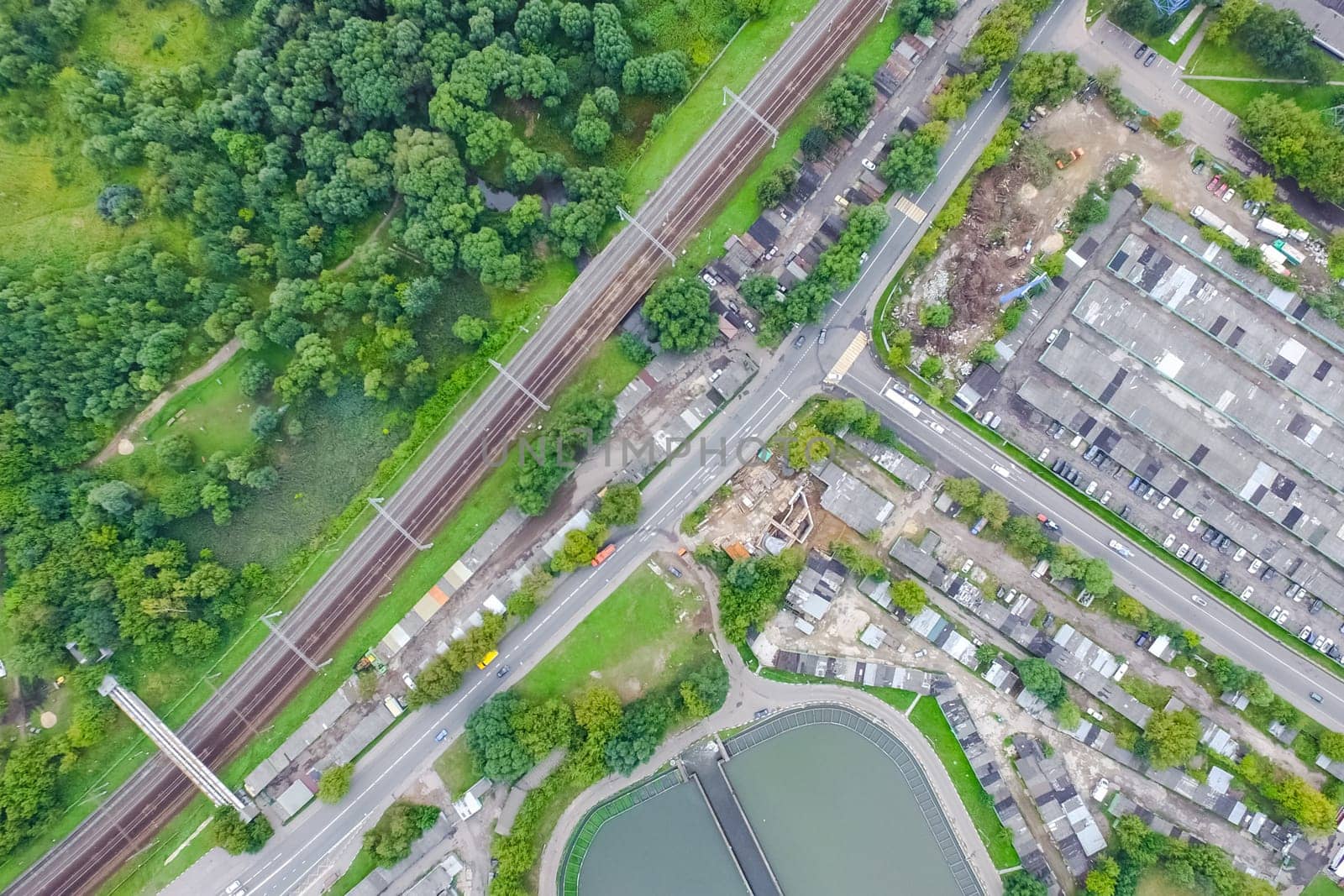 Top view of the urban lake. Lake, road in the city and parking