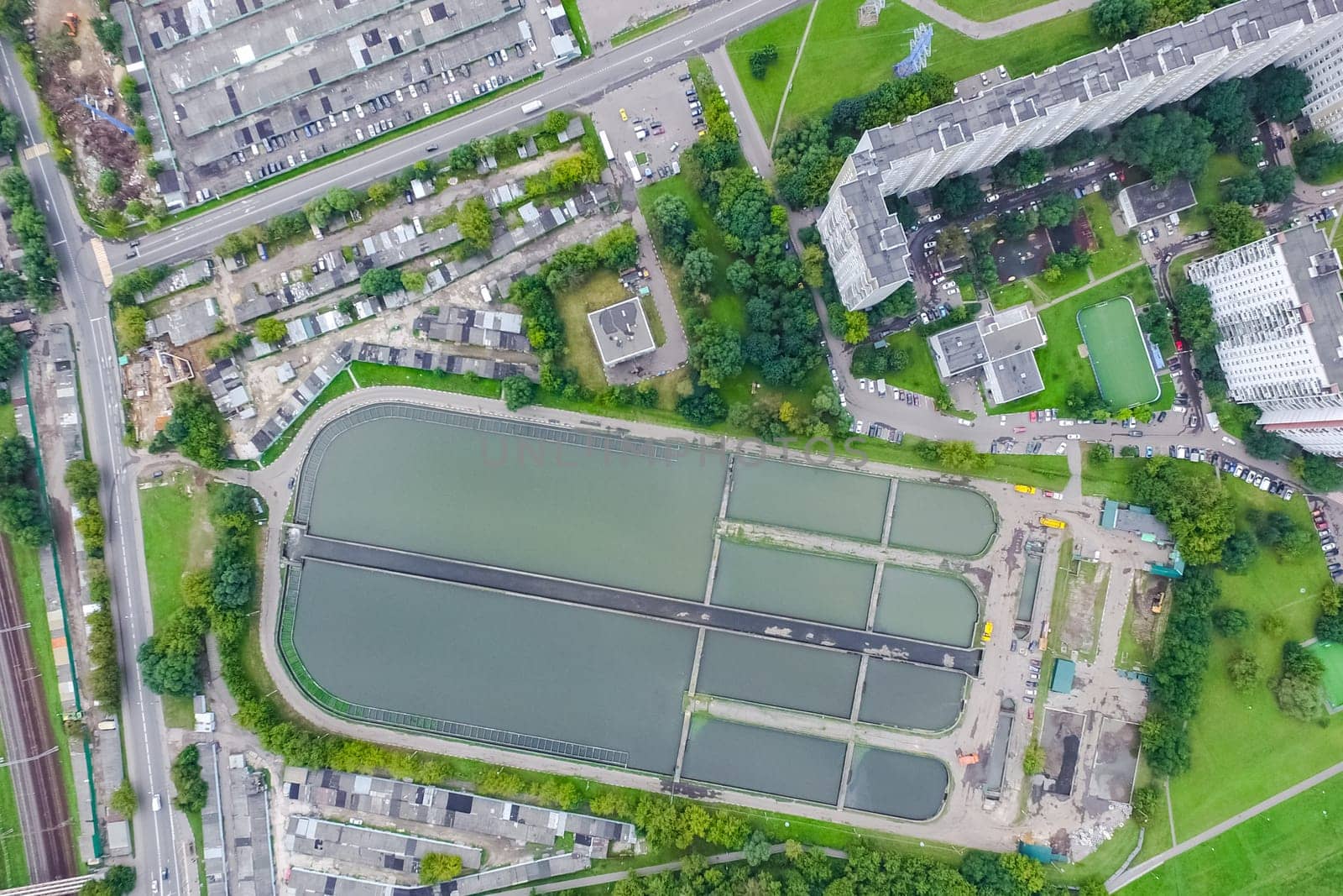 Top view of the urban lake. Lake, road in the city and parking