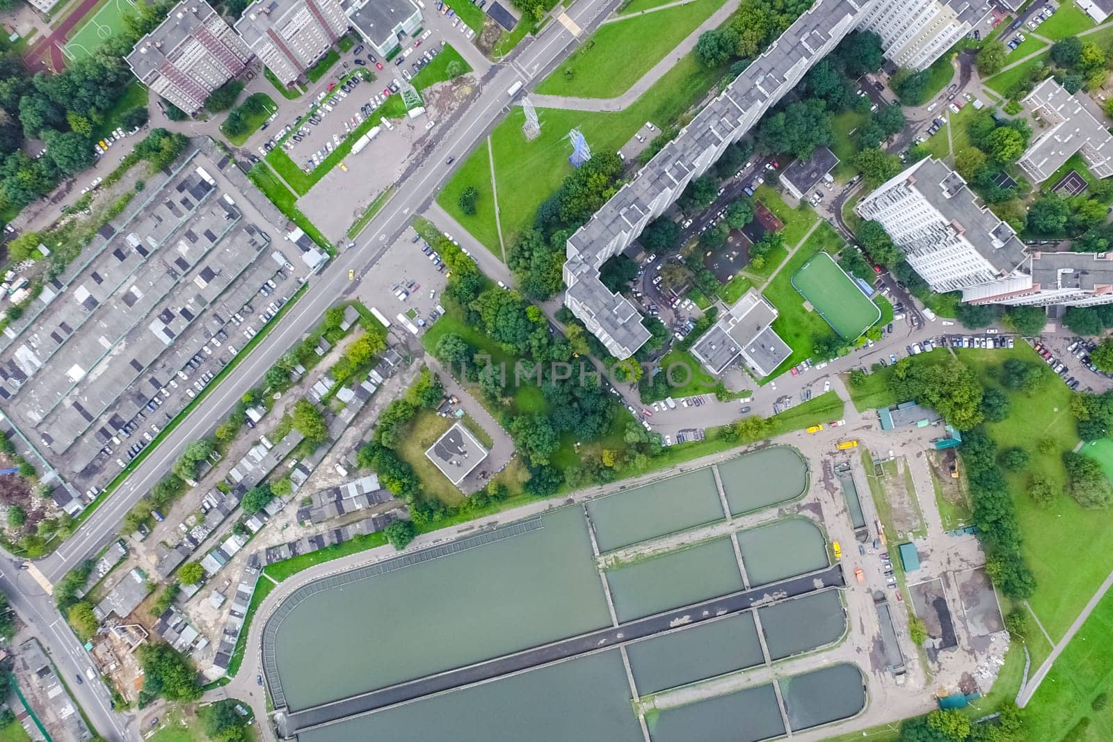 Top view of the urban lake. Lake, road in the city and parking