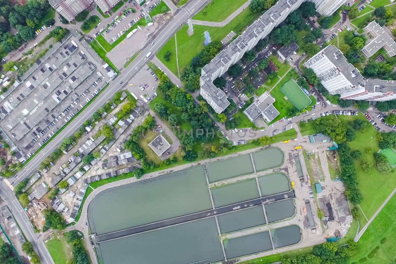 Top view of the urban lake. Lake, road in the city and parking
