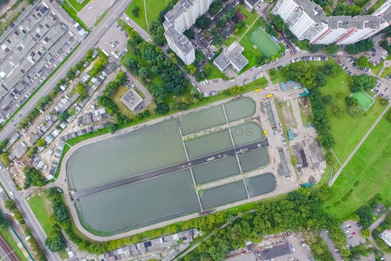 Top view of the urban lake. Lake, road in the city and parking