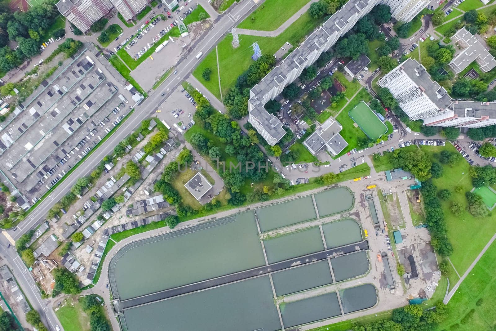 Top view of the urban lake. Lake, road in the city and parking