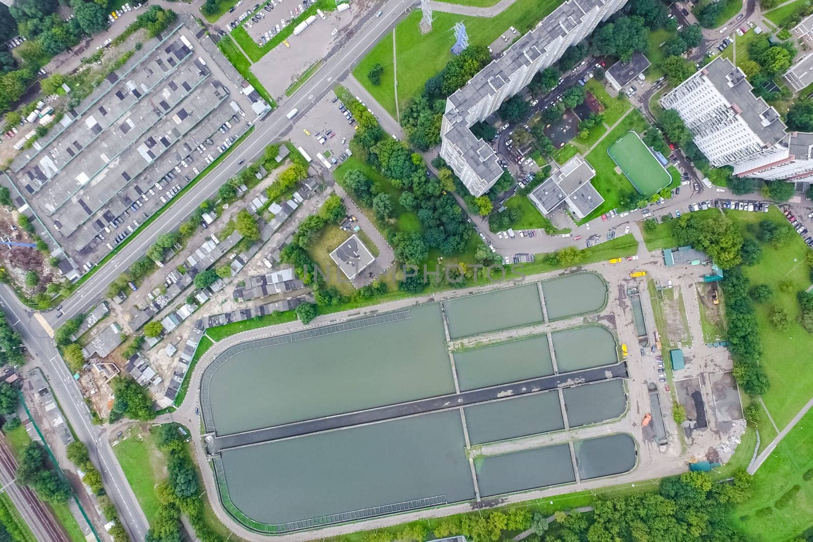 Top view of the urban lake. Lake, road in the city and parking