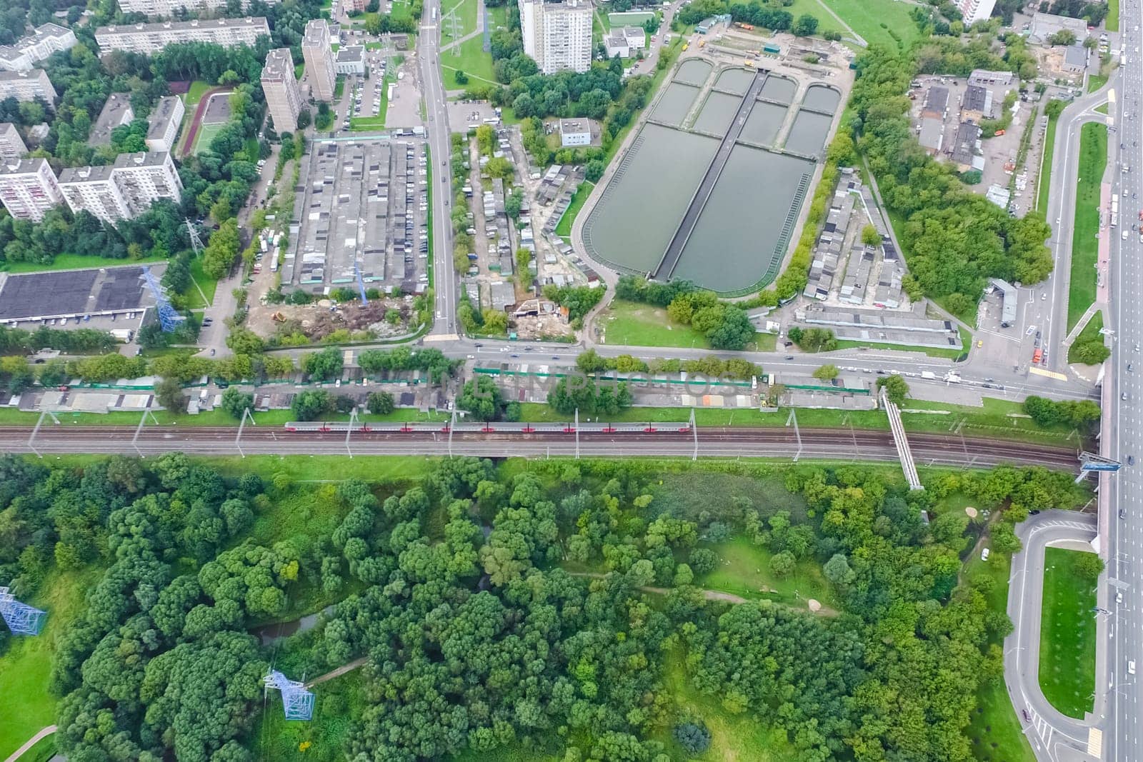 Top view of the urban lake. Lake, road in the city and parking