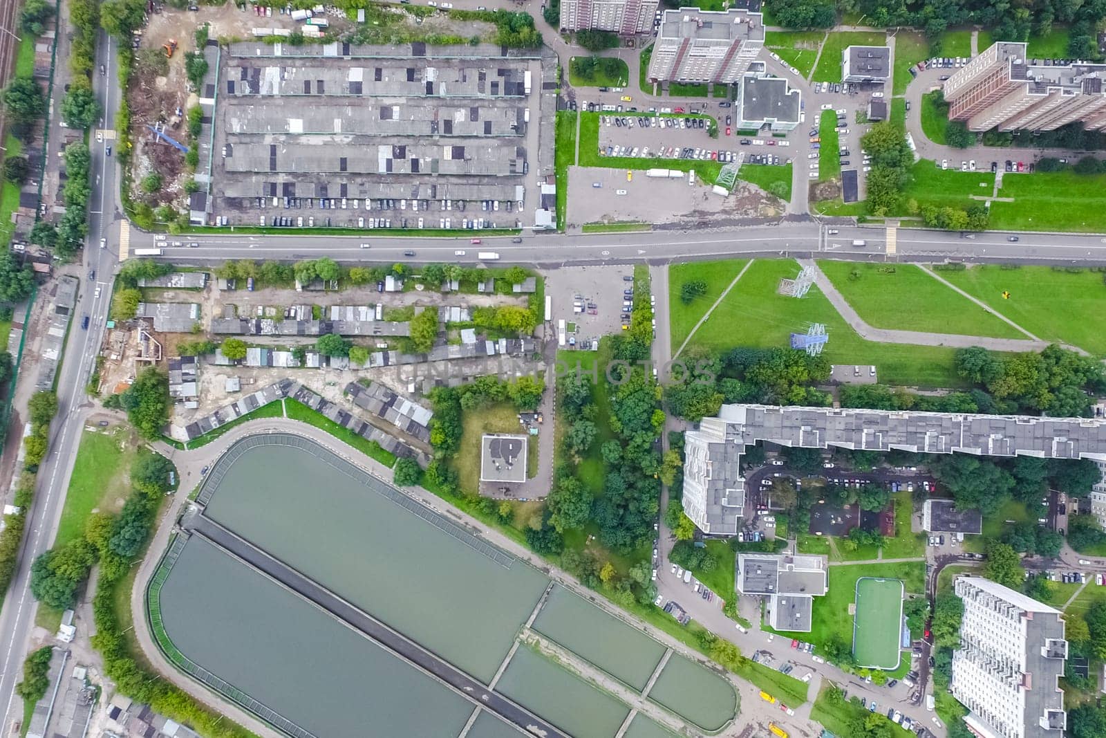Top view of the urban lake. Lake, road in the city and parking