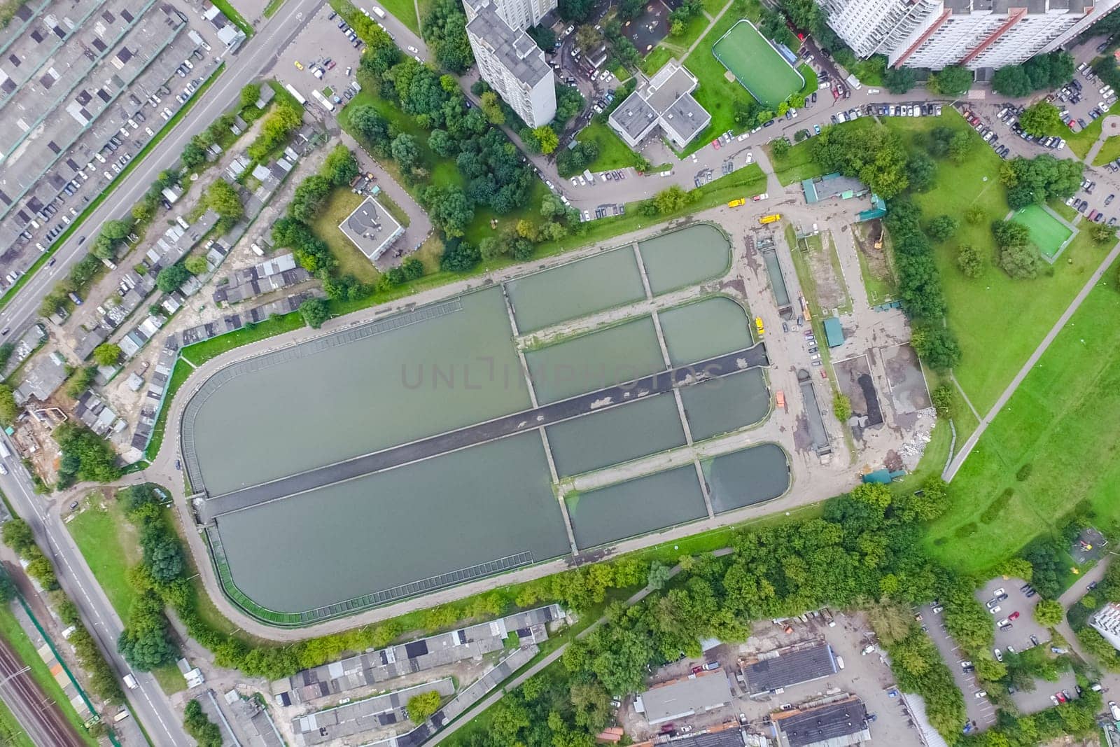 Top view of the urban lake. Lake, road in the city and parking