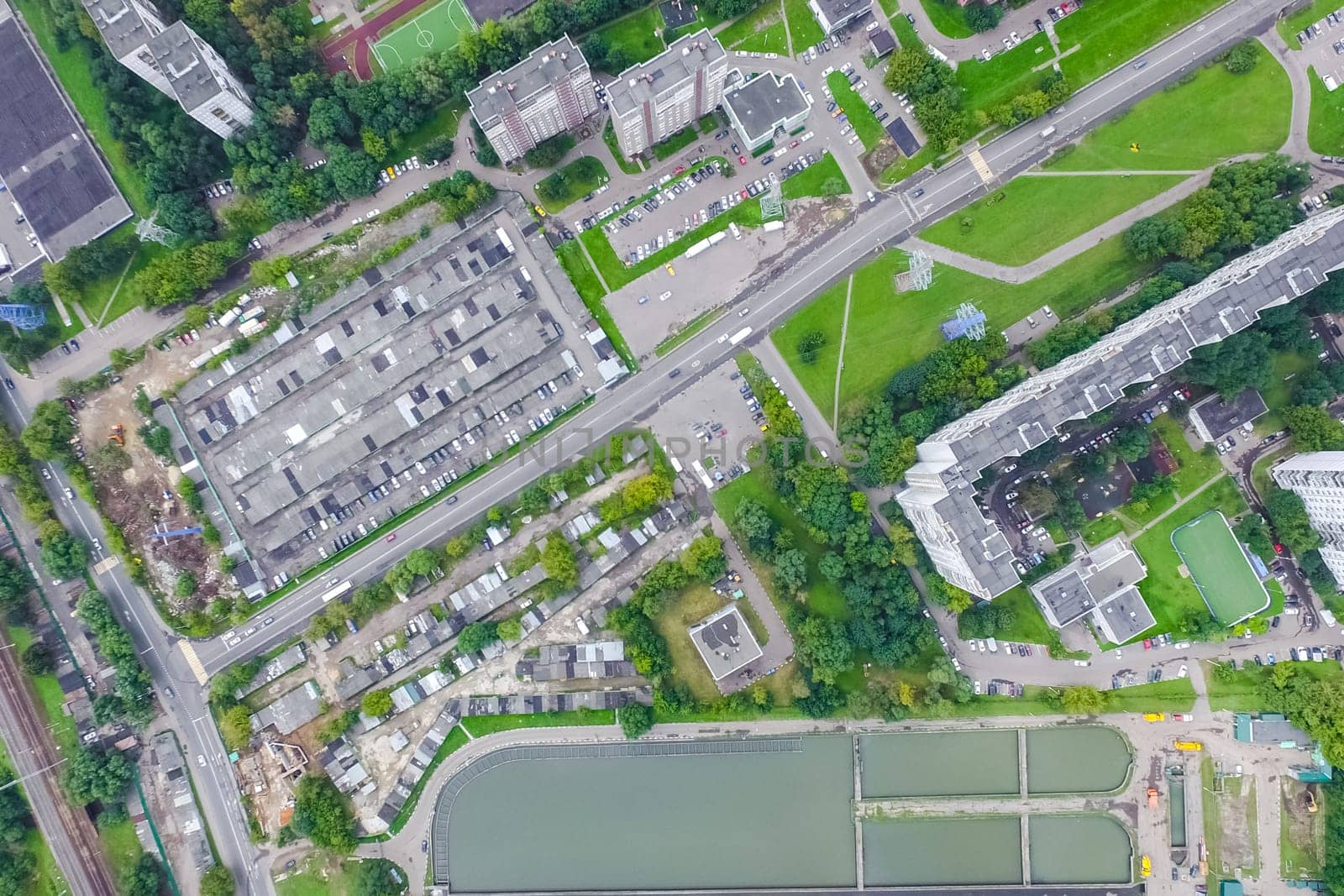 Top view of the urban lake. Lake, road in the city and parking