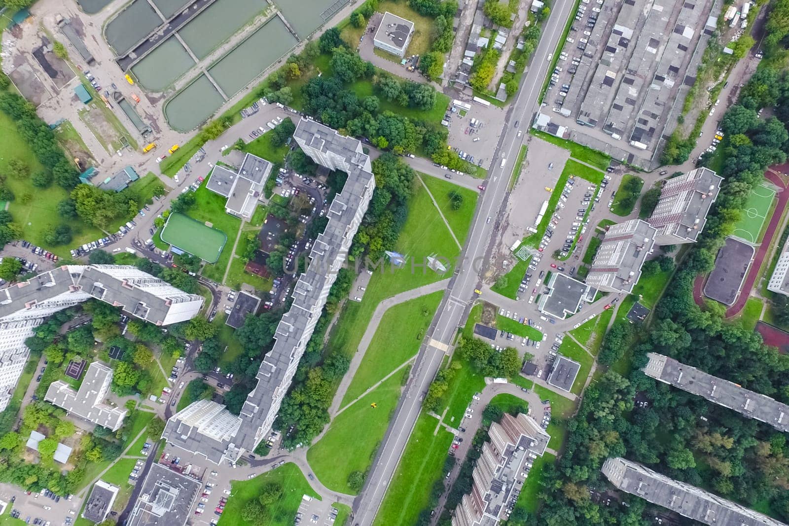 Top view of the urban lake. Lake, road in the city and parking