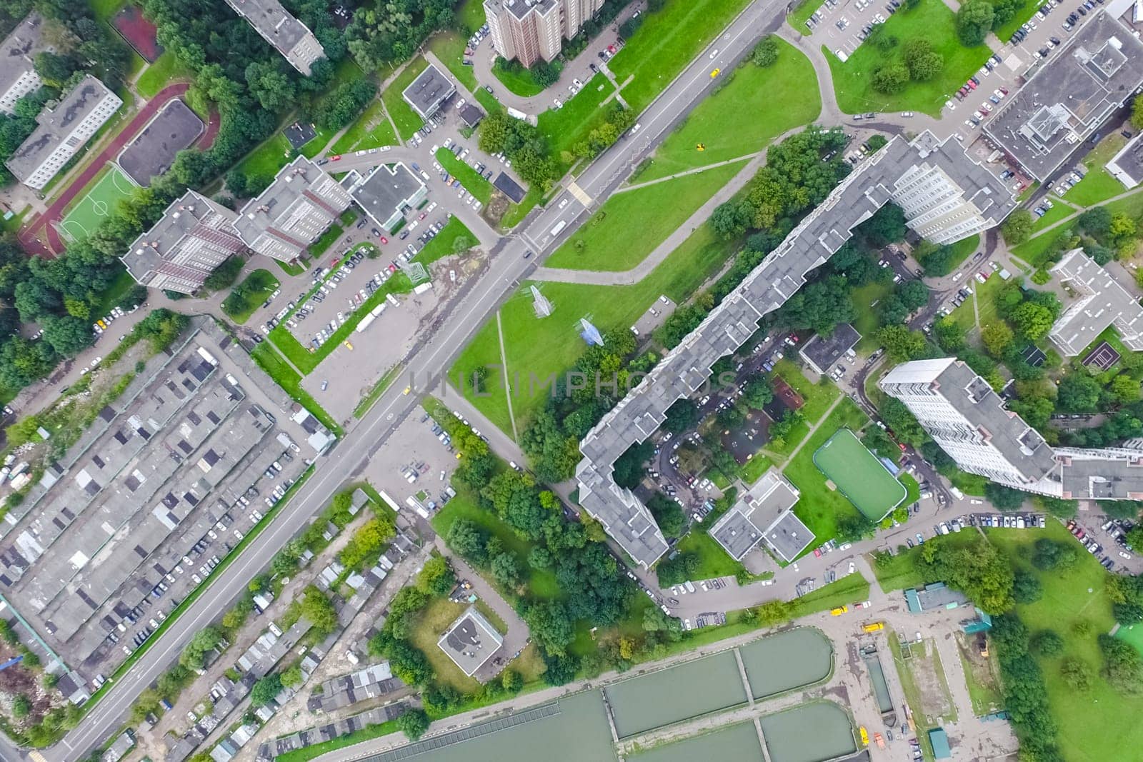 Top view of the urban lake. Lake, road in the city and parking