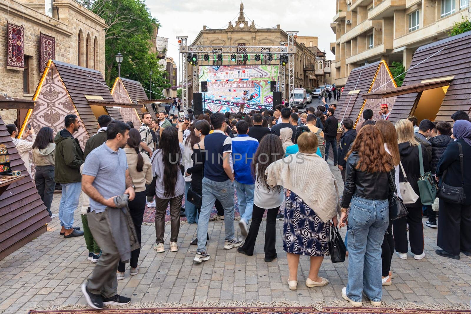 Baku, Azerbaijan - May 4 2024: Crowd gathers for a concert at the first National Carpet Festival of Azerbaijan. The event takes place in the Old Town, or Icherisheher, the historic walled city