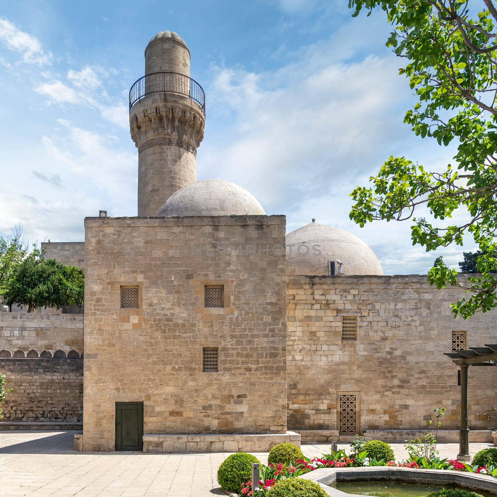 The Shah Mosque minaret rises above the surrounding buildings in Baku, Azerbaijan. Attached to the Palace of the Shirvanshahs, this mosque is a prominent landmark in the city