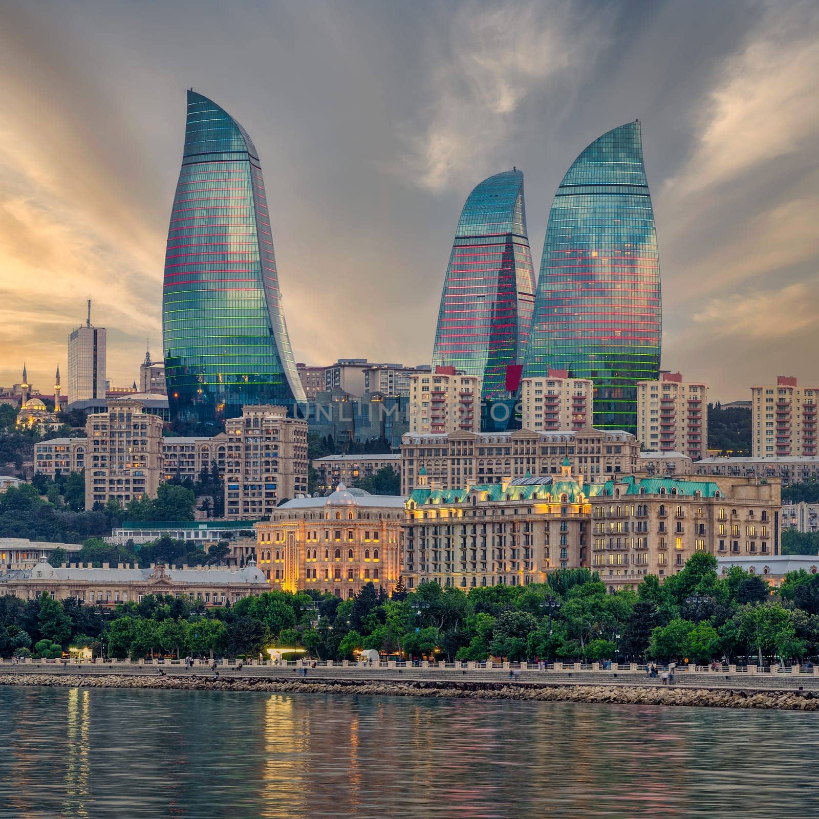Night view of the iconic illuminated Flame Towers in Baku, Azerbaijan, The modern architecture of the buildings is reflected in the calm waters of the Caspian Sea